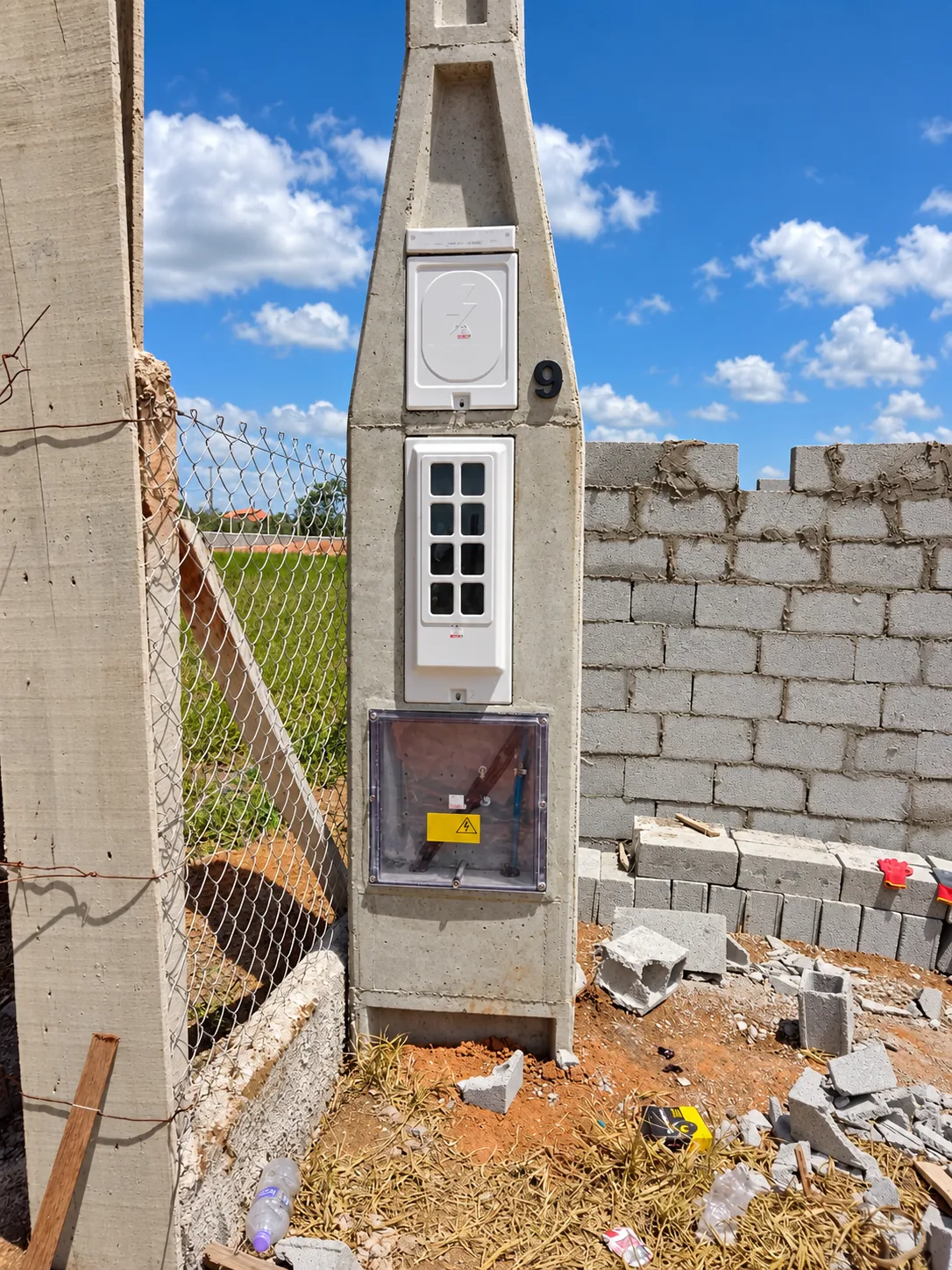 Poste do grupo C4 a C6 com quadro branco vertical junto a muro em construção